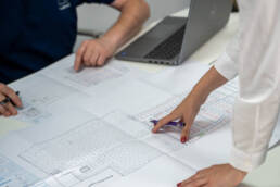 Hands pointing at a CAD design drawing analysing self storage growth