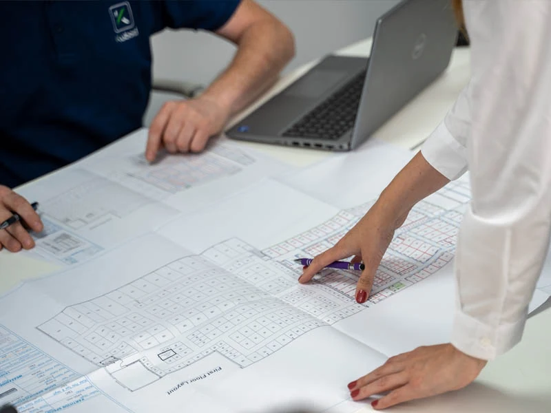 Hands pointing at a CAD design drawing analysing self storage growth